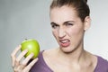 Disgusted woman unhappy with her apple Royalty Free Stock Photo