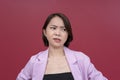 A disgusted young asian woman in her mid 20s looking repulsed at something to her right. Wearing a pink blazer and black tube top Royalty Free Stock Photo