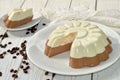 A dish with an appetizing mousse layer (vanilla and chocolate) cake on a wooden surface decorated with coffee beans