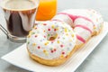 Dish with assorted donuts, coffee and juice Royalty Free Stock Photo