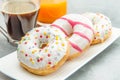 Dish with assorted donuts, coffee and juice Royalty Free Stock Photo