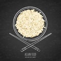 Dish of boiled white rice and chopsticks on grunge black chalkboard background. Top view.