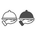 Dish with cap in hand line and solid icon, waiter service concept. Vector graphics. Hot dish sign on white background Royalty Free Stock Photo