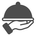 Dish with cap in hand solid icon, waiter service concept. Vector graphics. Hot dish sign on white background, glyph Royalty Free Stock Photo