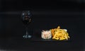 dish consisting of chicken breast breaded, french fries and salad, red wine in a glass, a dish on a black stone plate Royalty Free Stock Photo