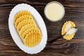 Dish with cookies, condensed milk in spoon on cookie, bowl with condensed milk on wooden table. Top view Royalty Free Stock Photo