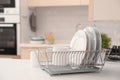 Dish drainer with clean dinnerware on table Royalty Free Stock Photo