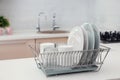 Dish drainer with clean dinnerware on table Royalty Free Stock Photo