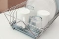 Dish drainer with clean dinnerware on table Royalty Free Stock Photo