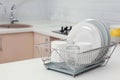 Dish drainer with clean dinnerware on table