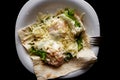 A dish of eggs. Fried eggs with pita bread, lettuce and cheese on a white and black plate Royalty Free Stock Photo