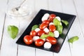 Dish with fresh caprese salad isolated on white Royalty Free Stock Photo