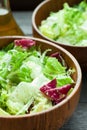 A dish of fresh salad frisse, Romano and radiccio with olive oil, salt and freshly ground percec in a wooden bowl Royalty Free Stock Photo