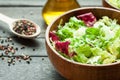 A dish of fresh salad frisse, Romano and radiccio with olive oil, salt and freshly ground percec in a wooden bowl Royalty Free Stock Photo