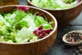 A dish of fresh salad frisse, Romano and radiccio with olive oil, salt and freshly ground percec in a wooden bowl Royalty Free Stock Photo