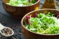 A dish of fresh salad frisse, Romano and radiccio with olive oil, salt and freshly ground percec in a wooden bowl Royalty Free Stock Photo