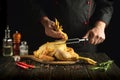 Dish of fried chicken by the hands of the cook in the kitchen of the restaurant. Preparing to cook a raw rooster on a cutting