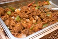 A dish of fried curry flavoured meat on a large open tray