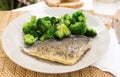 Dish of fried dorado fish fillet with boiled broccoli