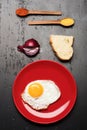 Dish with fried egg near spoons with spices, bread, onion Royalty Free Stock Photo