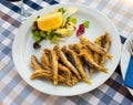 Dish with fried sardines, pilchards or anchovies in batter for traditional Spanish meal Royalty Free Stock Photo