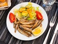 Dish with fried sardines, pilchards or anchovies in batter for traditional Spanish meal Royalty Free Stock Photo