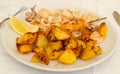 The dish of Fritto con spiedino e patate - potatoes and seafood fried, italian food