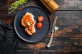 Dish of grilled pork chop with tomatoes top view with knife and fork over old rustic dark wood table table top view space for text Royalty Free Stock Photo