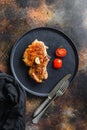 Dish of grilled pork chop with tomatoes top view with knife and fork over old rustic metall table top view Royalty Free Stock Photo