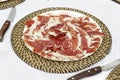 Dish of iberian ham slices over white tablecloth Royalty Free Stock Photo