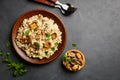 A dish of Italian cuisine - risotto from rice and mushrooms in a brown plate on a black slate background. Royalty Free Stock Photo