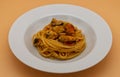 Dish of Italian Spaghetti with mussels and tomato soup, isolated on orange background Royalty Free Stock Photo