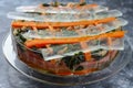 a dish with layered vegetable terrine and clear gel strips