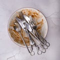 Dish of leftovers with knifes, forks and spoon