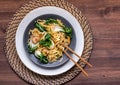 A dish of lo mein noodles with baby bok choy, cremini mushrooms and pork.