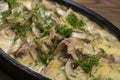 dish made of pieces of beef, mushroom in cream sauce on dark wood