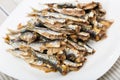 Dish of many tasty baked in oven anchovy served on plate at table