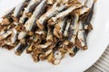 Dish of many tasty baked in oven anchovy served on plate at table