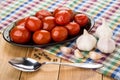 Dish with marinated tomatoes, garlic, black pepper and spoon Royalty Free Stock Photo