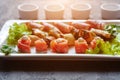 A dish with mini-canapes of salmon, eggplant and ham rolls with different fillings for a buffet and a festive table