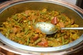 A dish mixed of curry and sliced long beans, corn, carrot, tomato and onions