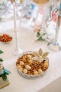 Dish with nuts decorated with a flower made from seeds is on the table near the candles. Tradition of Sofreh Aghd Royalty Free Stock Photo