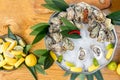 Dish with oysters, lemons, chili and leaves on ice