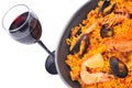 Dish of paella with a glass of red wine close-up on white background Royalty Free Stock Photo