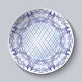 Dish painted with blue national patterns in the style of painting on porcelain isolated on gray.