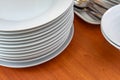 Dish, plates, bowls, spoon, fork are arranging and preparing on wood table for buffet lunch or dining., have space for text below Royalty Free Stock Photo