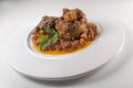 Dish with portion of oxtail stewed with parsley