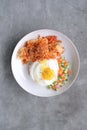 A Dish of Rice Bowl, with Crispy Fried Chicken Skin, with Indonesian Pickles, and Sunny Side Up Egg.