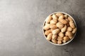 Dish with ripe pecan nuts on table, top view