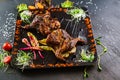 A dish with roasted quail meat with vegetables on black background Royalty Free Stock Photo